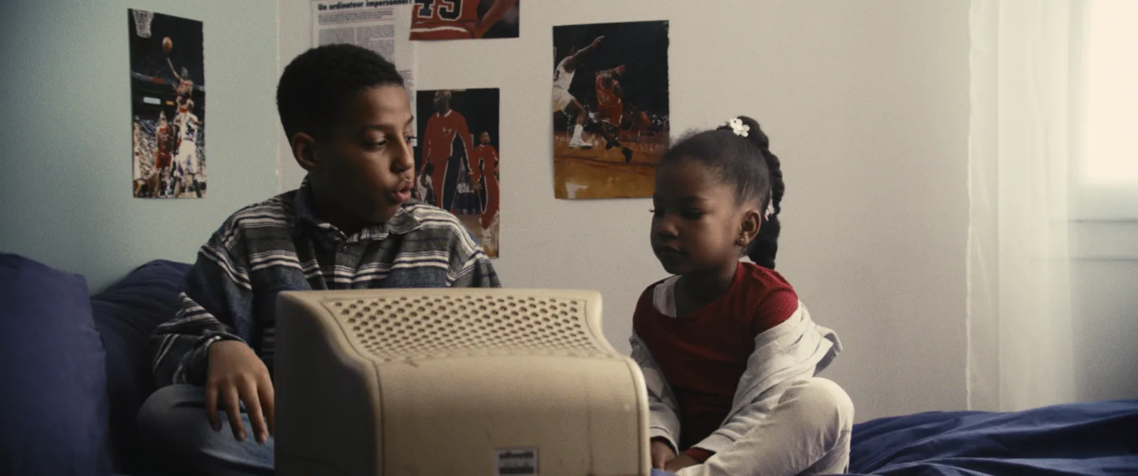 Deux enfants devant un écran, image du court-métrage L'Enfant Orange
